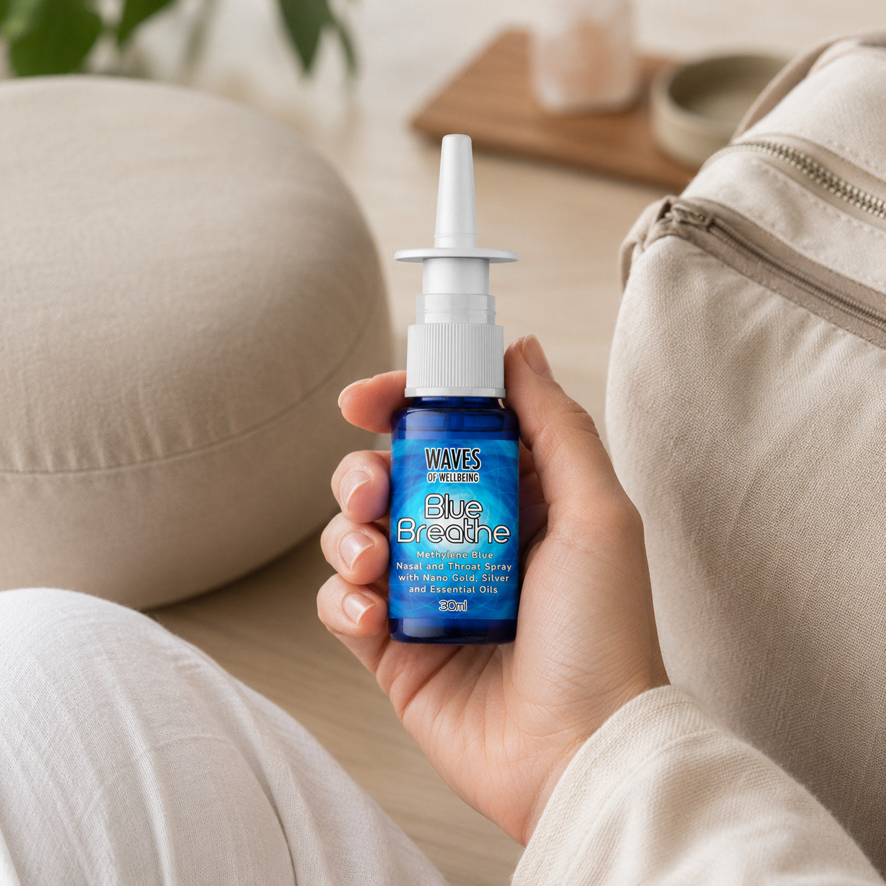 Hand holding Blue Breathe nasal spray bottle in a calm meditation setting