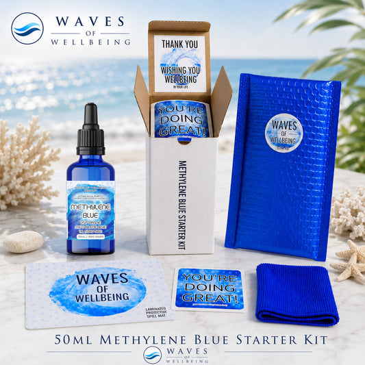 Waves of Wellbeing 50ml Methylene Blue Starter Kit — bottle, bubble mailer, spill mat, microfibre cloth and welcome cards on marble with coastal background